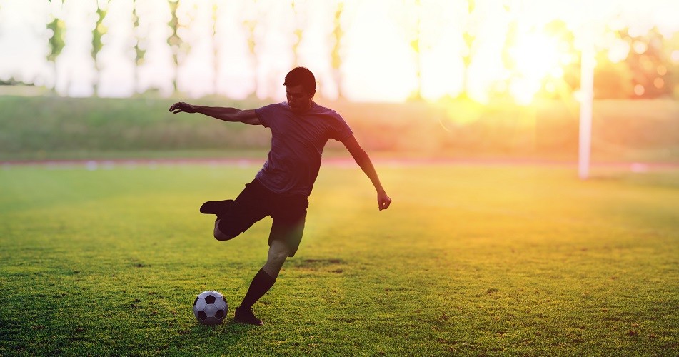 footballer kicking football